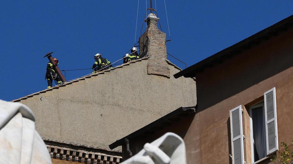 Los bomberos instalan la chimenea en la Capilla Sixtina para la ‘fumata’ del cónclave
